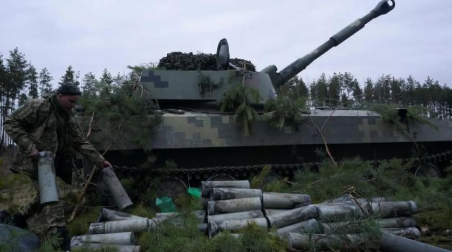 Ukraynalı bir asker, boş bir obüs mermisi tutuyor (Reuters)