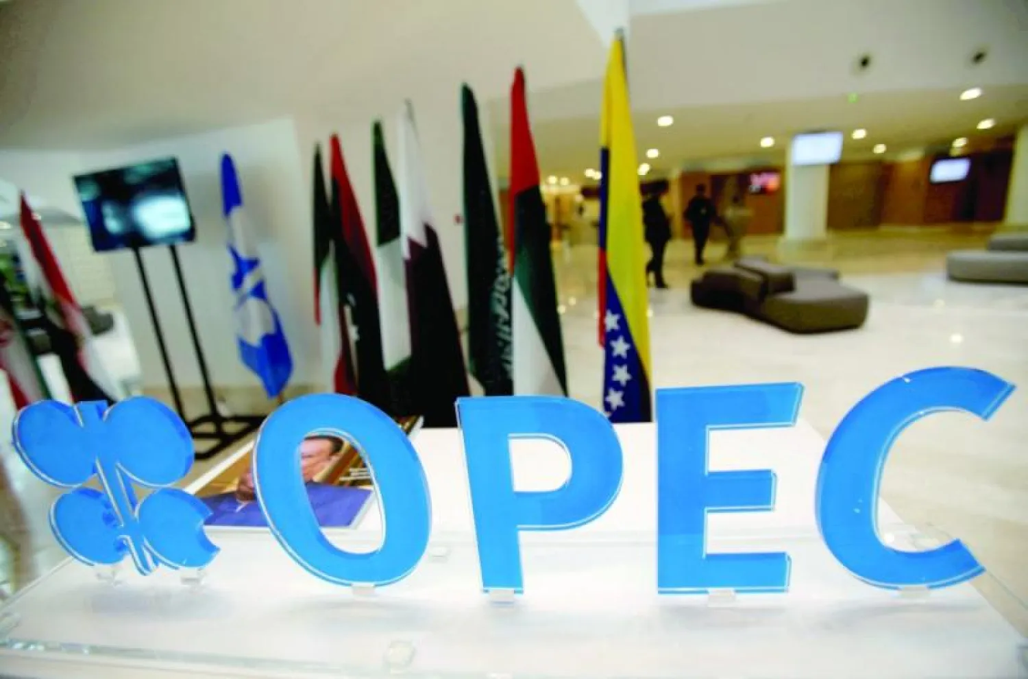 شعار {أوبك} على باب المنظمة بمقرها الرئيسي في فيينا وخلفه أعلام الدول الأعضاء (رويترز)