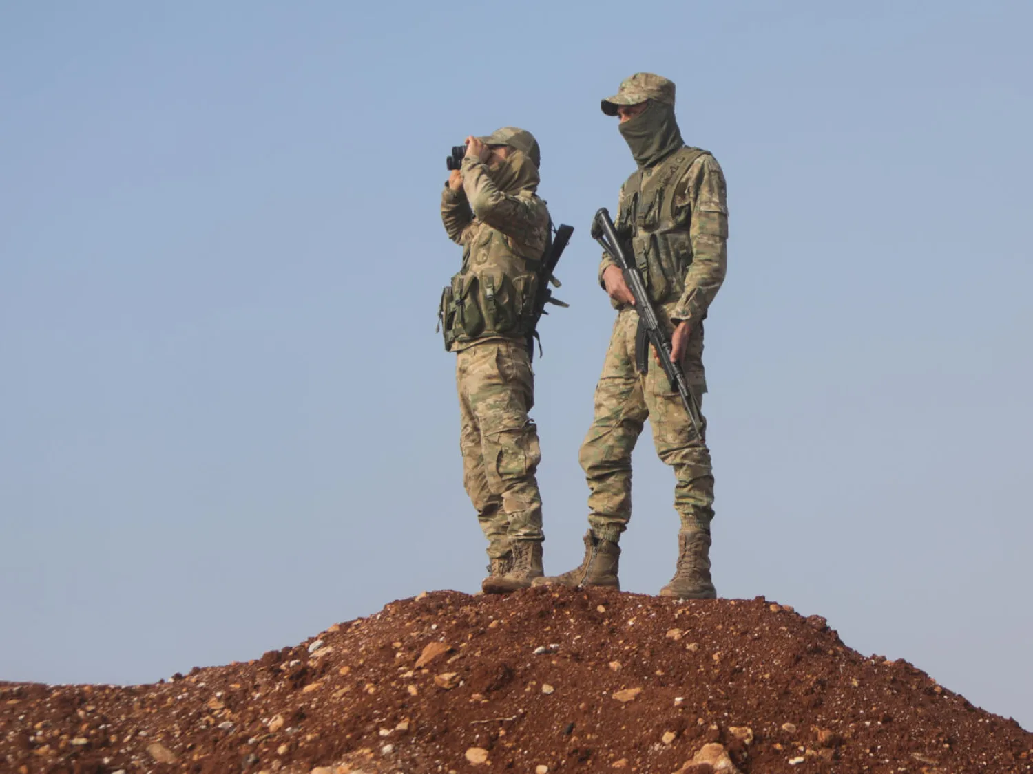 Turkish-backed Syrian fighters keep watch on the front line with Kurdish forces in Tal Rifaat, awaiting orders from Turkish President Recep Tayyip Erdogan on whether to proceed with a threatened ground offensive. Bakr ALKASEM / AFP
