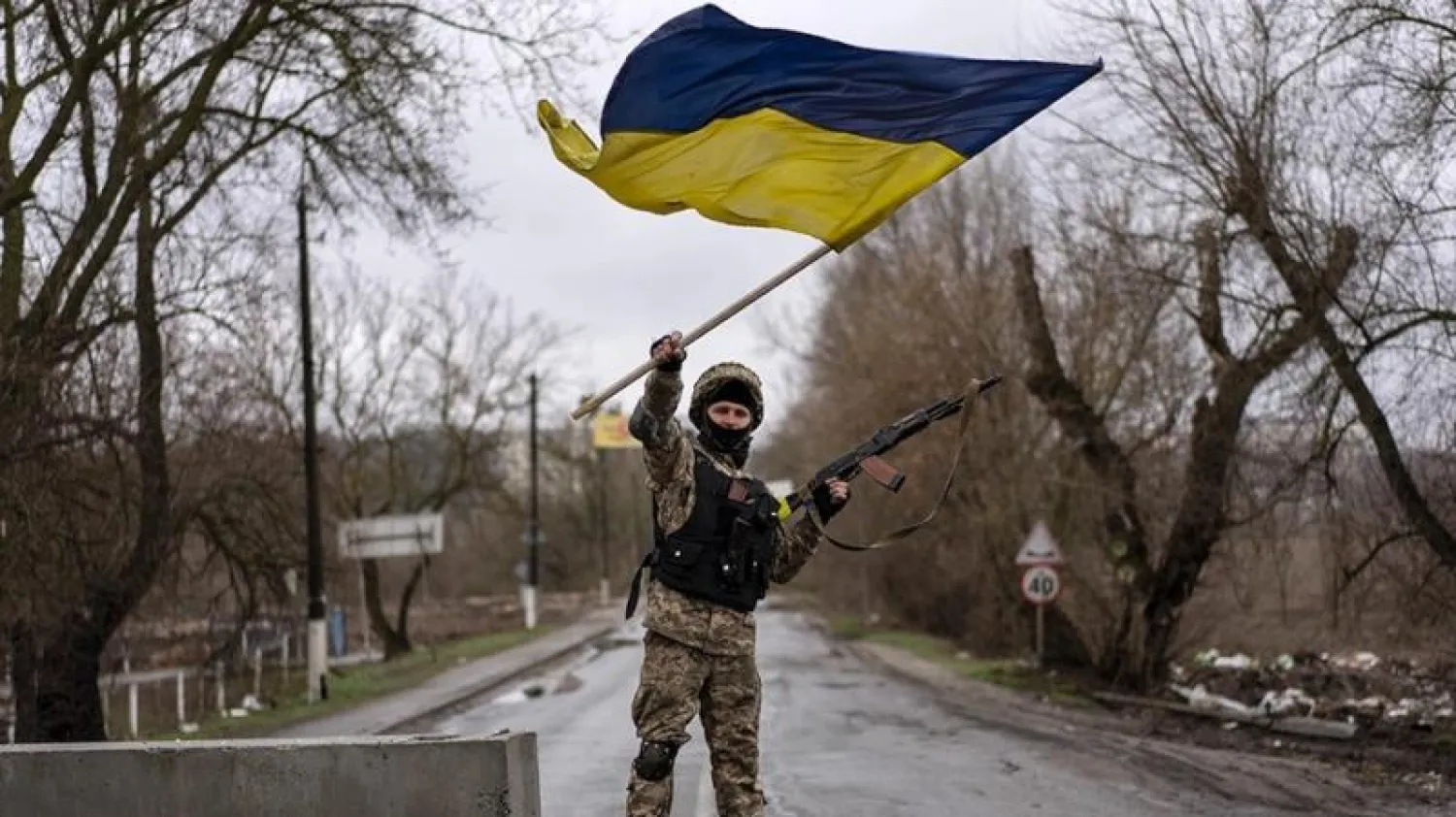 جندي أوكراني يلوّح بعلَم بلاده كرمز للانتصار (أ.ب)