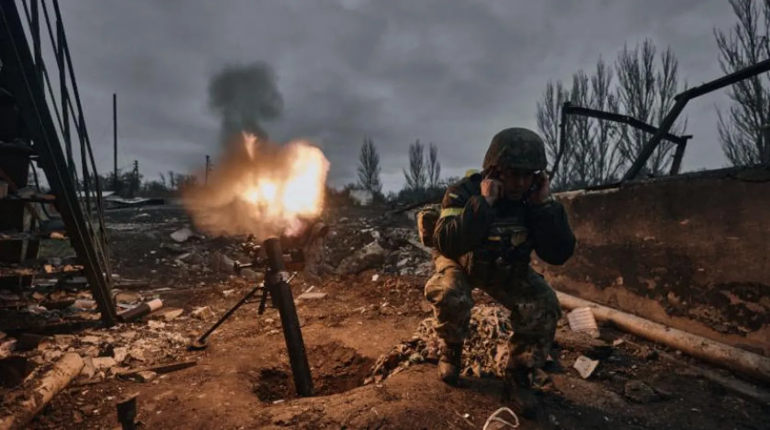 Ukraynalı bir asker, Donetsk bölgesinin Bakhmut'ta Rus mevzilerine havan topu ateşliyor (AP)
