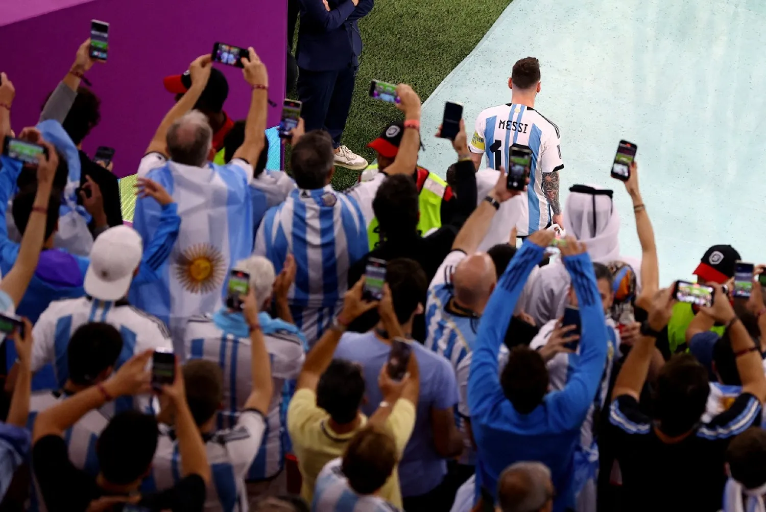 Football - FIFA World Cup Qatar 2022 - Round of 16 - Argentina v Australia - Ahmad bin Ali Stadium, Al Rayyan, Qatar - December 3, 2022 Fans take photos as Argentina's Lionel Messi leads his team out before the match. (Reuters)