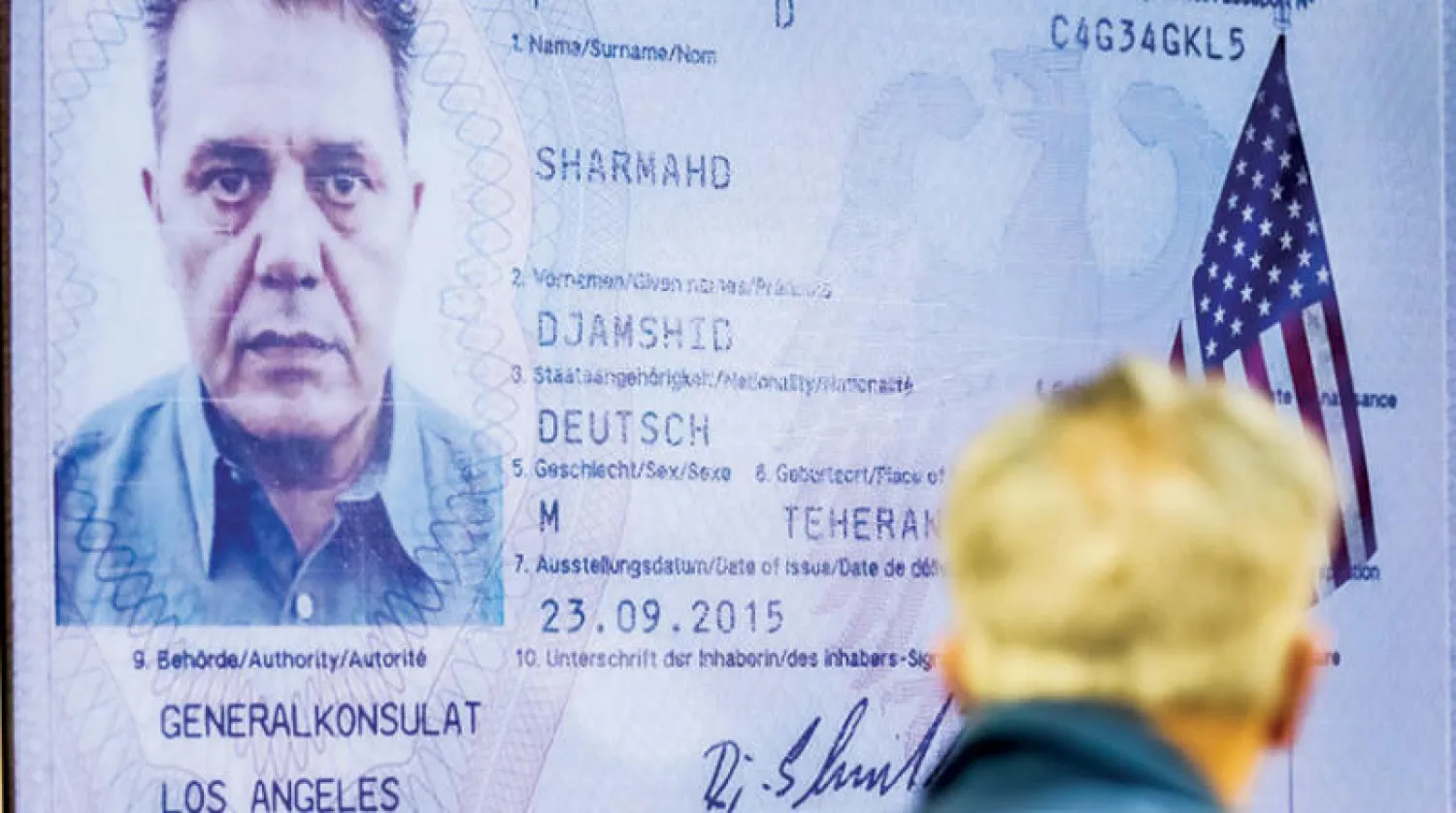 صورة نشرها القضاء الإيراني لشارمهد وهو ينظر إلى شاشة تظهر تأشيرة الدخول لأميركا على جواز سفره الألماني بمحكمة في طهران