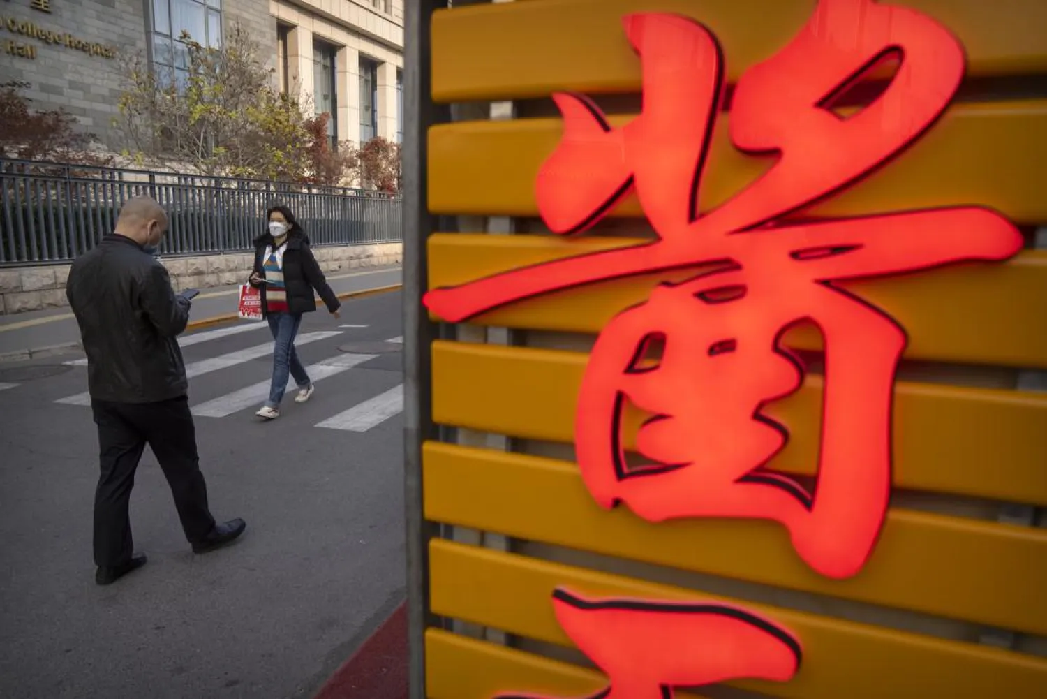 People wearing face masks walk in the Wangfujing shopping district in Beijing, Saturday, Nov. 19, 2022. (AP Photo/Mark Schiefelbein)