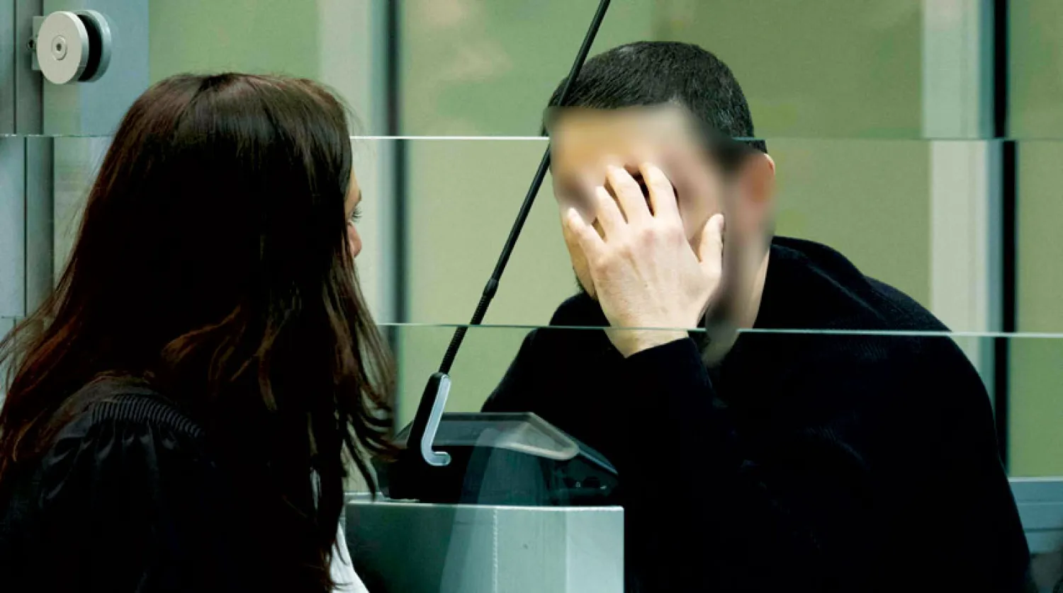 المشتبه به محمد عبريني يتحدث إلى محاميته خلال جلسات المحاكمة (أ.ف.ب)