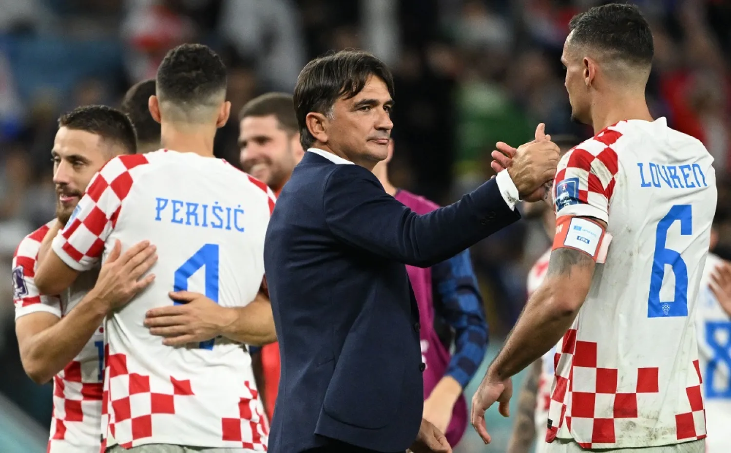 Croatia's coach #00 Zlatko Dalic (C) congratulates Croatia's defender #06 Dejan Lovren for their win in the Qatar 2022 World Cup round of 16 football match between Japan and Croatia at the Al-Janoub Stadium in Al-Wakrah, south of Doha on December 5, 2022. (AFP)