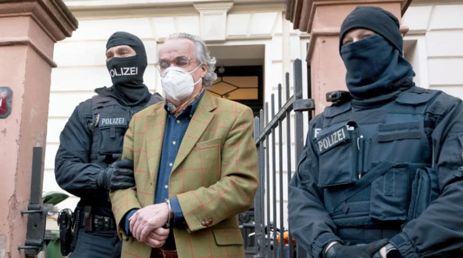 زعيم المجموعة المتطرفة هاينريخ الثالث عشر رويس بين شرطيين بعد اعتقاله في فرانكفورت أمس (أ.ب)