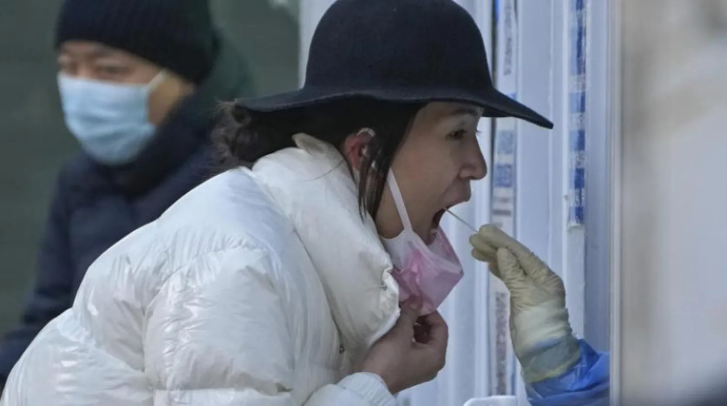 Pazar günü Pekin'de bir kadın korona testinden geçiyor (AP)
