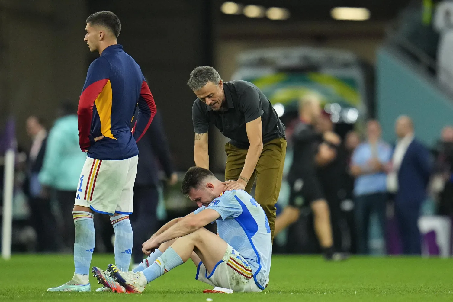 Spain's head coach Luis Enrique consoles Aymeric Laporte at the end of the World Cup round of 16 soccer match between Morocco and Spain, at the Education City Stadium in Al Rayyan, Qatar, Tuesday, Dec. 6, 2022. (AP Photo/Julio Cortez)