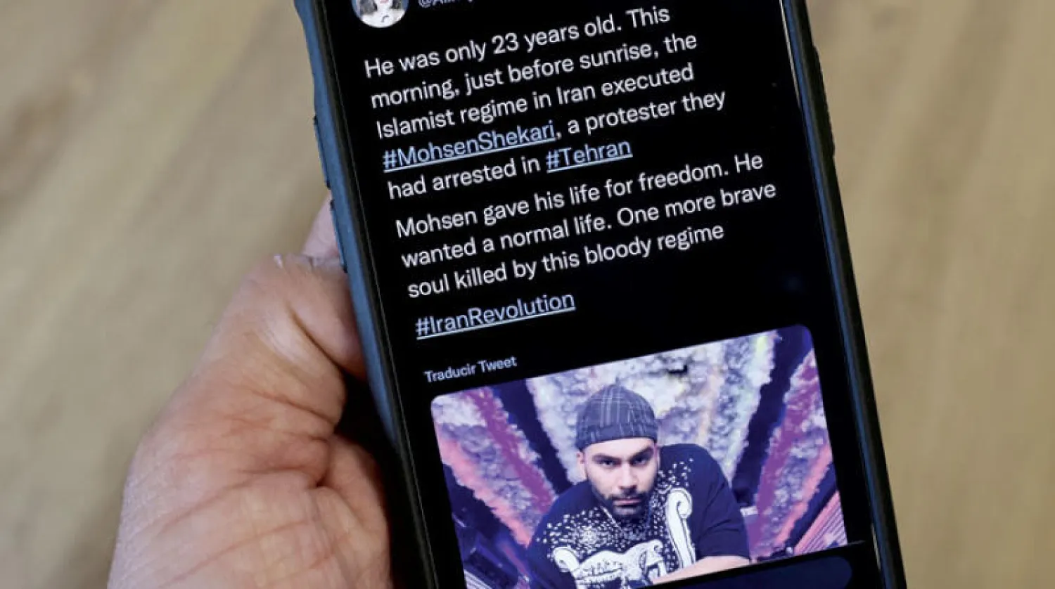 شخص يقرأ في جواله تغريدة عن إعدام شكاري (أ.ف.ب)