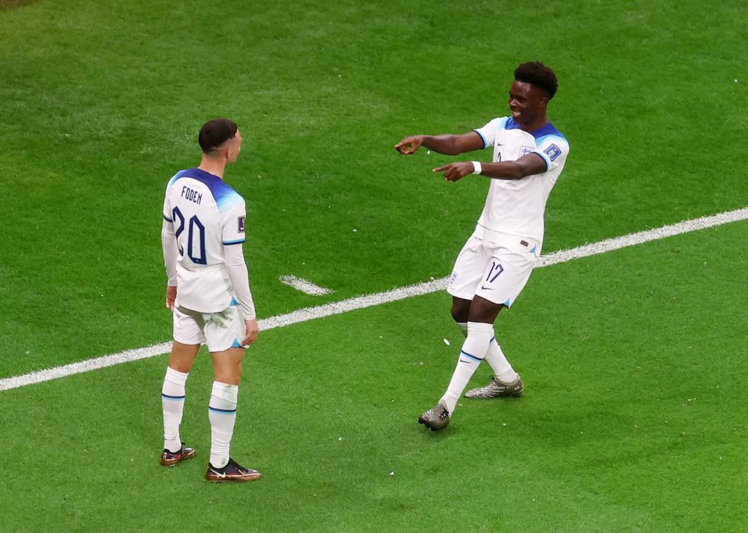 Soccer Football - FIFA World Cup Qatar 2022 - Round of 16 - England v Senegal - Al Bayt Stadium, Al Khor, Qatar - December 4, 2022 England's Bukayo Saka celebrates scoring their third goal with Phil Foden REUTERS/Paul Childs 