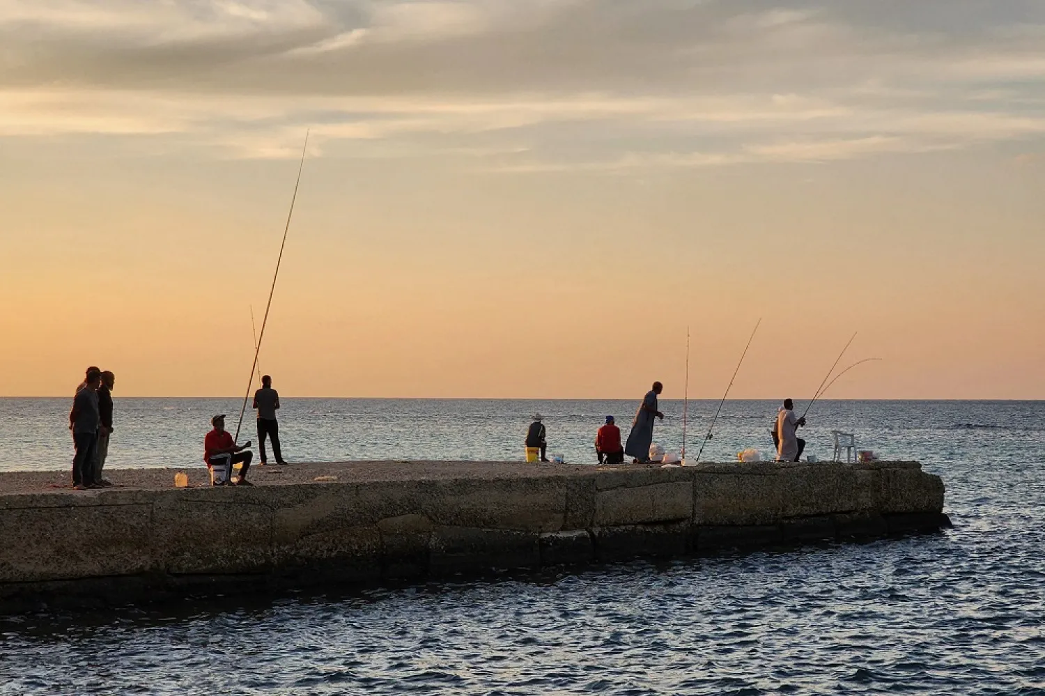 Libyan men fish in the Mediterranean Sea at the capital Tripoli's waterfront on October 17, 2022. (AFP)