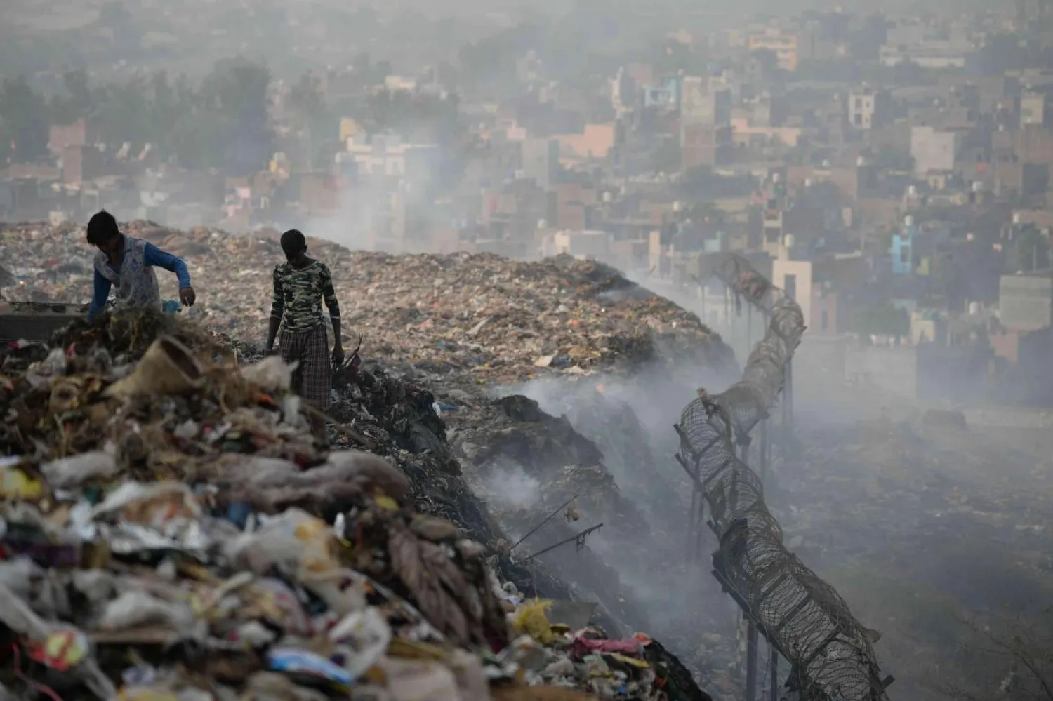 Metan sızıntısı ve yangınlara rağmen yüzlerce kişi Yeni Delhi'nin çöp dağlarında dönüştürülebilir malzeme topluyor (AFP)
