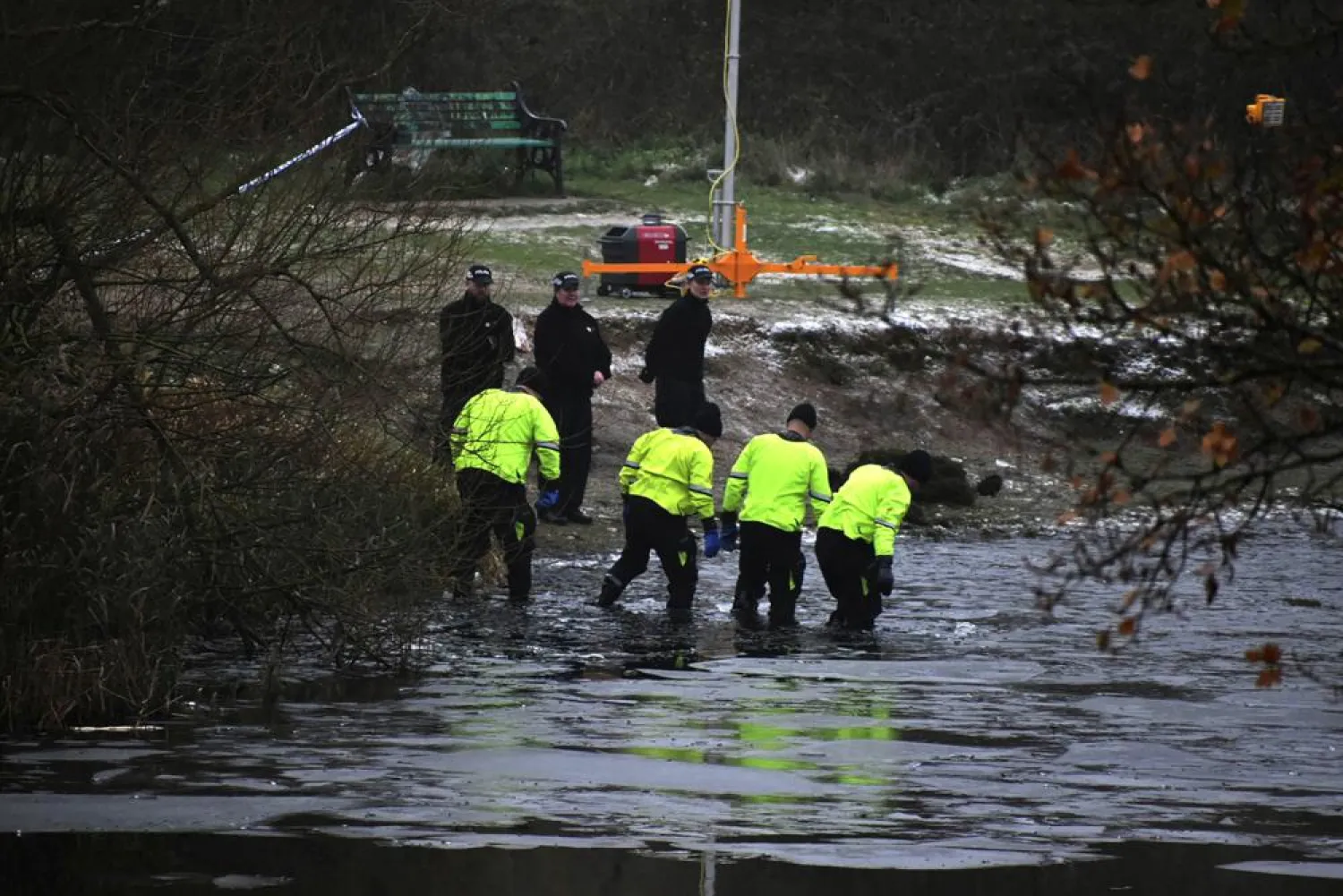 Police search teams at the scene after children fell through ice,in Babbs Mill Park in Kingshurst, Solihull, England, Monday, Dec. 12, 2022. (Matthew Cooper/PA via AP)