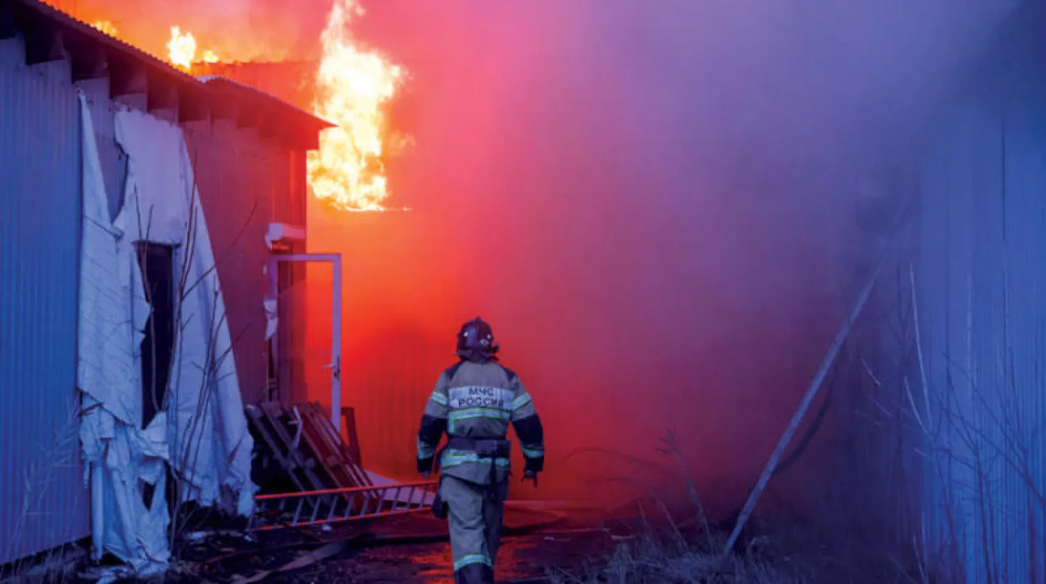 محاولات لإخماد حريق ناجم عن قصف في دونيتسك أمس (إ.ب.أ)