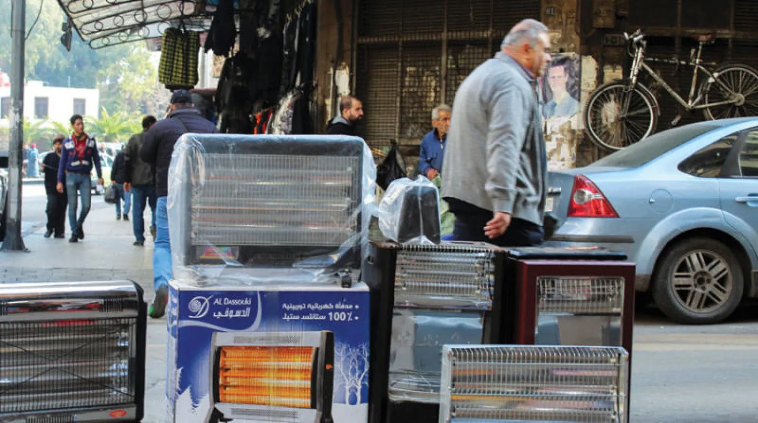 سوري يمر بجانب أجهزة تدفئة معروضة للبيع في إحدى أسواق دمشق (رويترز)