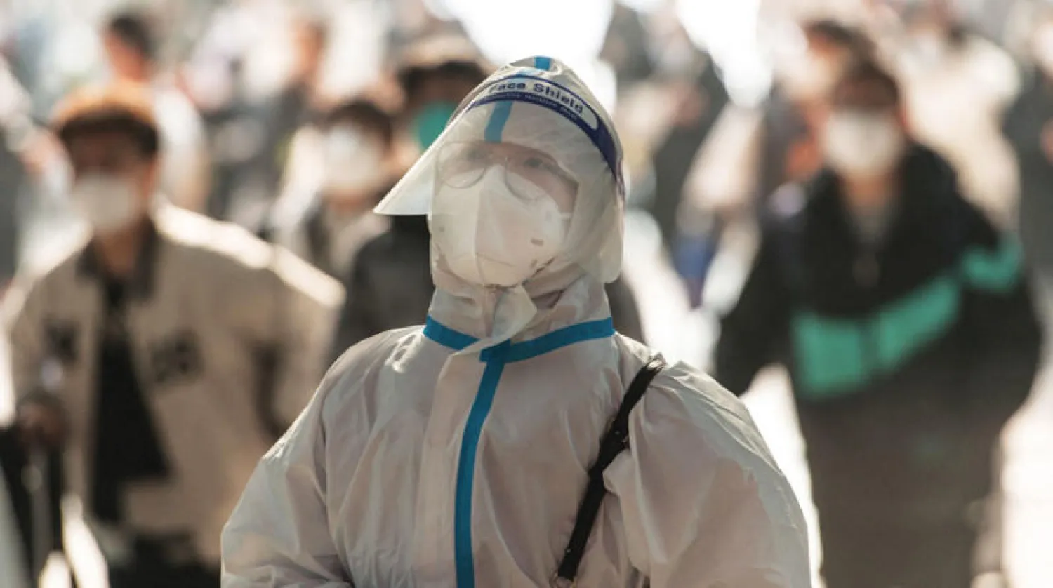 صيني برداء واق كامل في محطة قطارات في مدينة ووهان في 10 ديسمبر الحالي (أ.ف.ب)