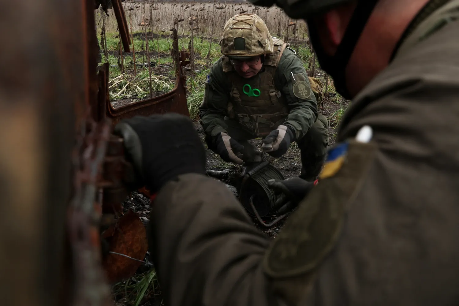 جندي أوكراني يفكك قذائف غير منفجرة بالقرب من أوتشاكيف (أ.ف.ب)