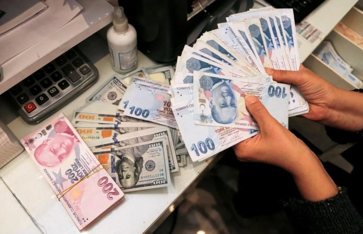 صراف يحمل أوراقاً نقدية من الليرة التركية في مركز للصيرفة في 12 أكتوبر 2021 (رويترز)