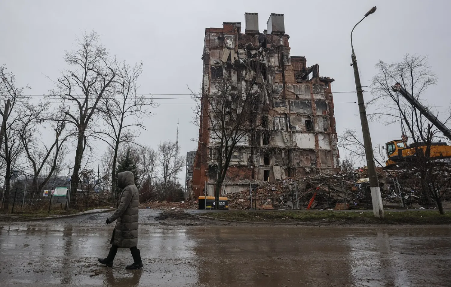 A local man walks in front of a destroyed building in downtown Mariupol, Ukraine, 12 December 2022. (EPA)