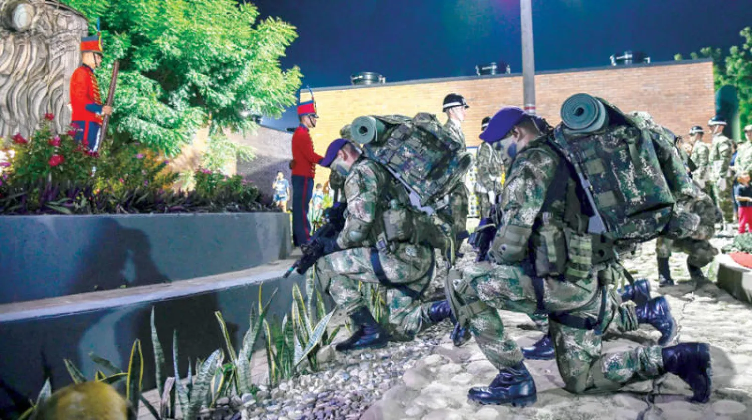 جنود كولومبيون يكرّمون ضحايا هجوم شنه متمردو «فارك» في كوكوتا يوم 9 ديسمبر الماضي (أ.ف.ب)