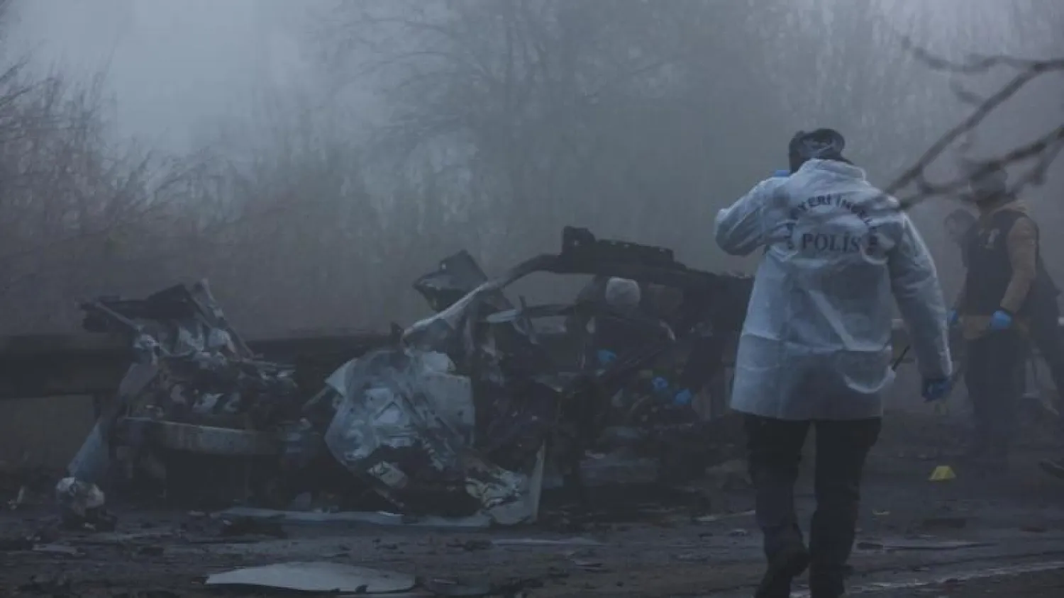 خبراء الأدلة الجنائية في الشرطة يعاينون الموقع بعد انفجار قنبلة في سيارة على جانب الطريق أثناء مرور حافلة صغيرة للشرطة في ديار بكر (رويترز)