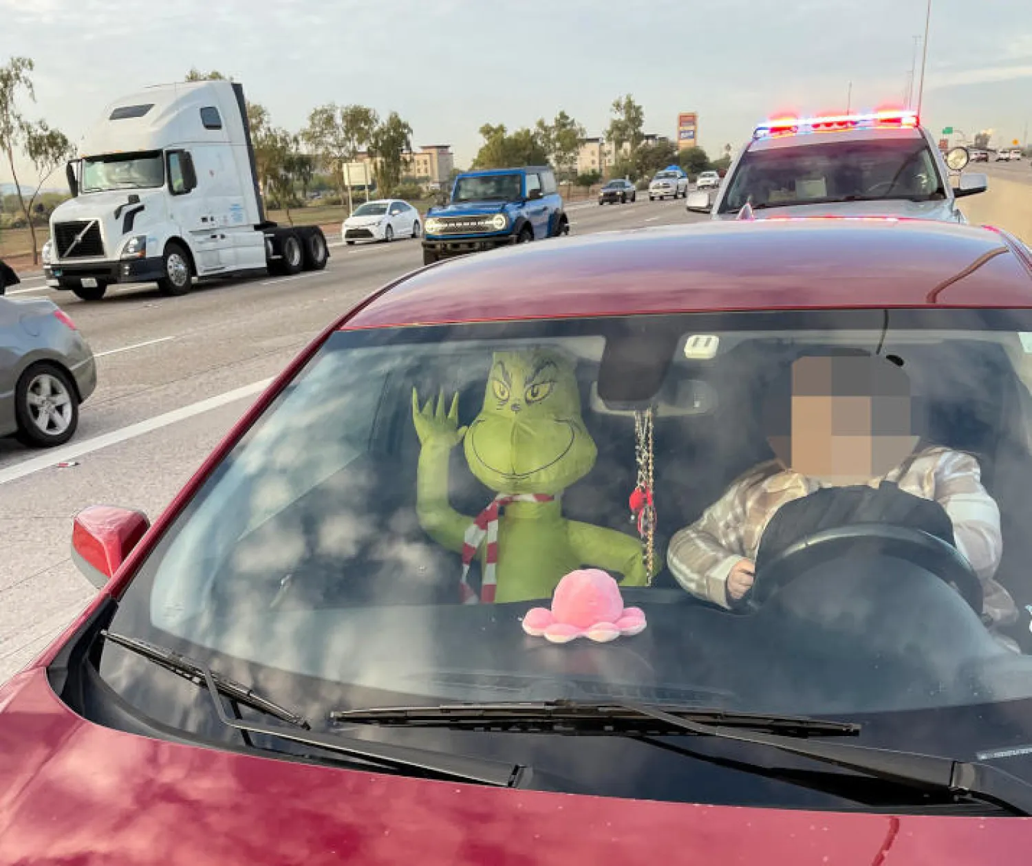 المرافق الأخضر الموجود إلى جانب السائق ليس إلاّ دمية قابلة للنفخ تمثّل شخصية الوحش الذي يتولّى بحسب القصص تخريب عيد الميلاد (أ.ف.ب)