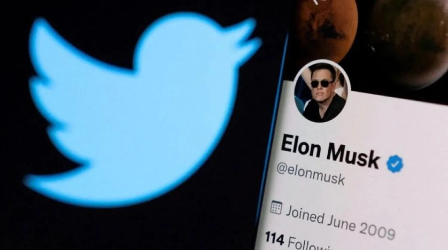 Elon Musk's Twitter account is seen on a smartphone in front of the Twitter logo in this photo illustration taken, April 15, 2022. REUTERS/Dado Ruvic/Illustration
