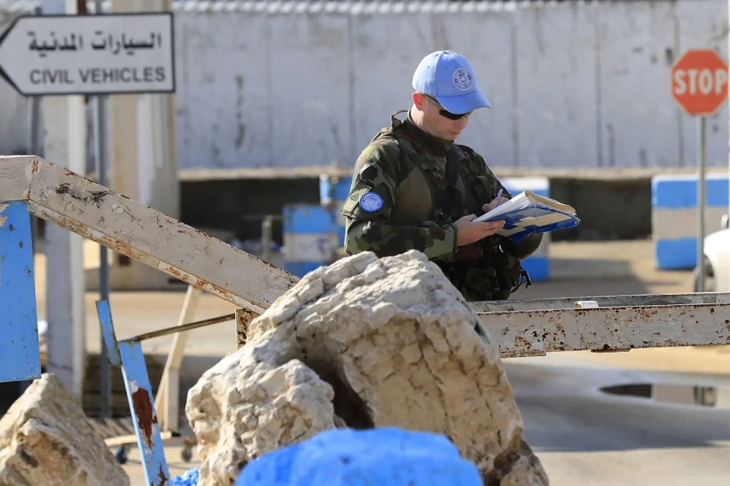 An Irish UN soldier, takes notes as he stand guards at entrance of the Irish UN peacekeepers base, in Tireh village, south Lebanon, Friday Dec. 16, 2022. (AP)