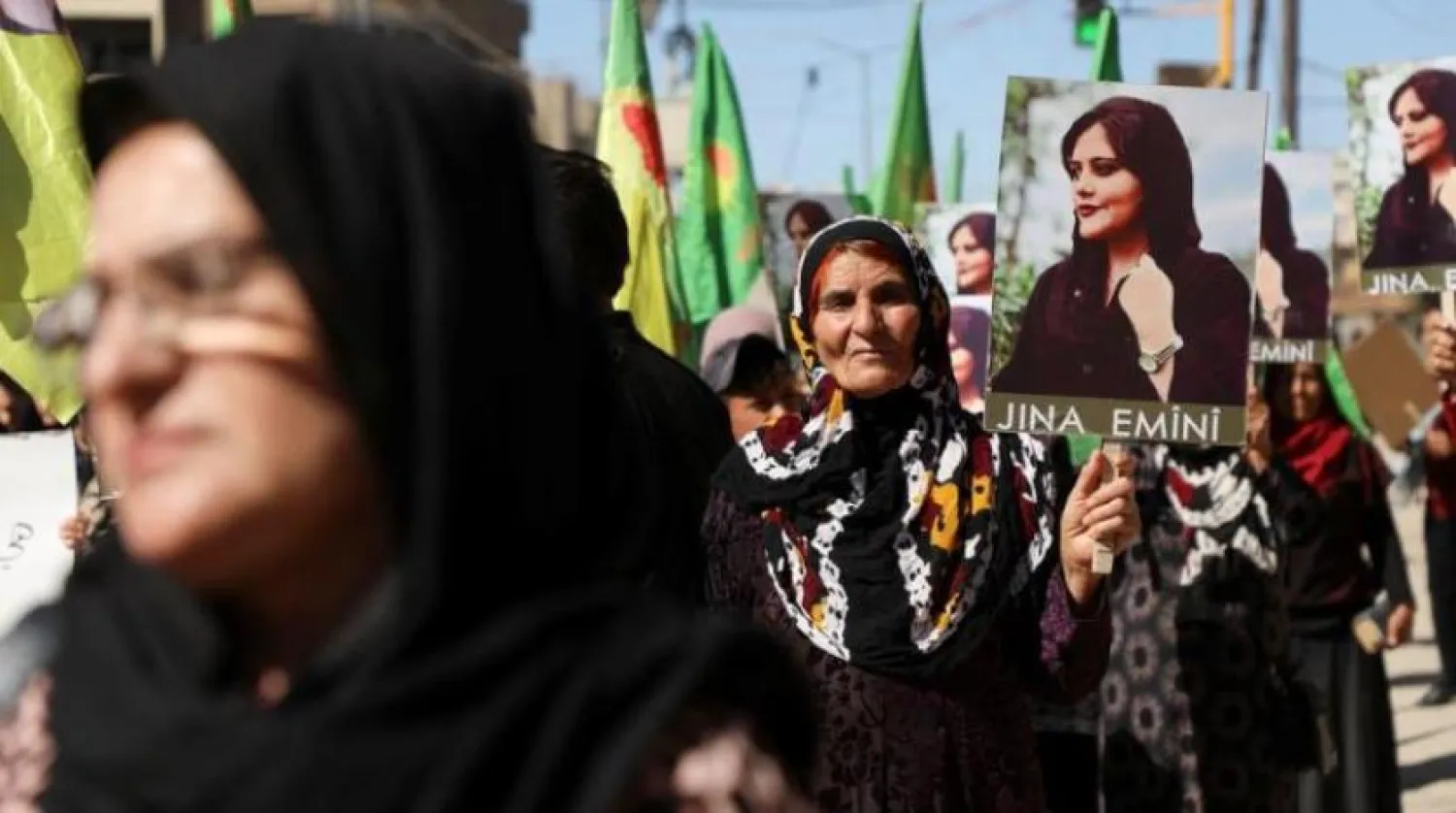 İran’da Mahsa Amini’nin ölümünü protesto eden kadınlar fotoğraflarını taşıyor (Reuters)