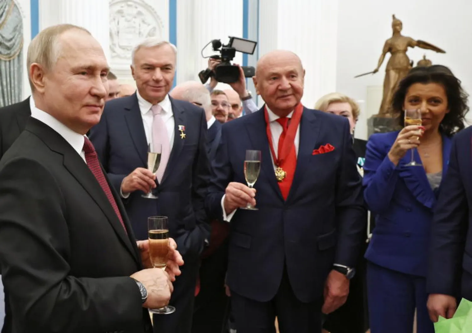 الرئيس الروسي فلاديمير بوتين مع أشخاص كرّمهم اليوم (إ.ب.أ)