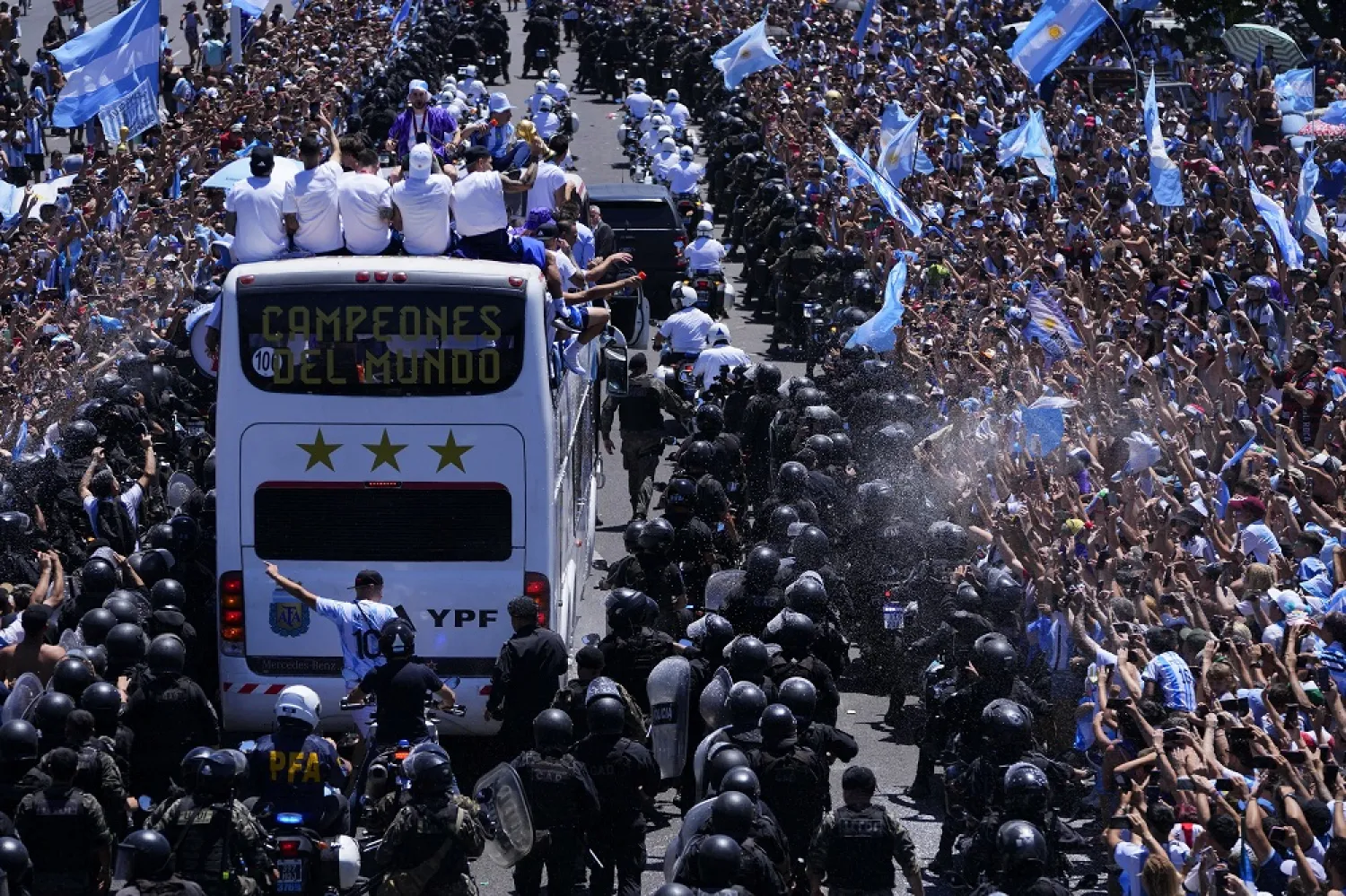 The Argentine football team shows off their World Cup trophy from a bus as they are welcomed home in Buenos Aires, Argentina, Tuesday, Dec. 20, 2022. (AP)