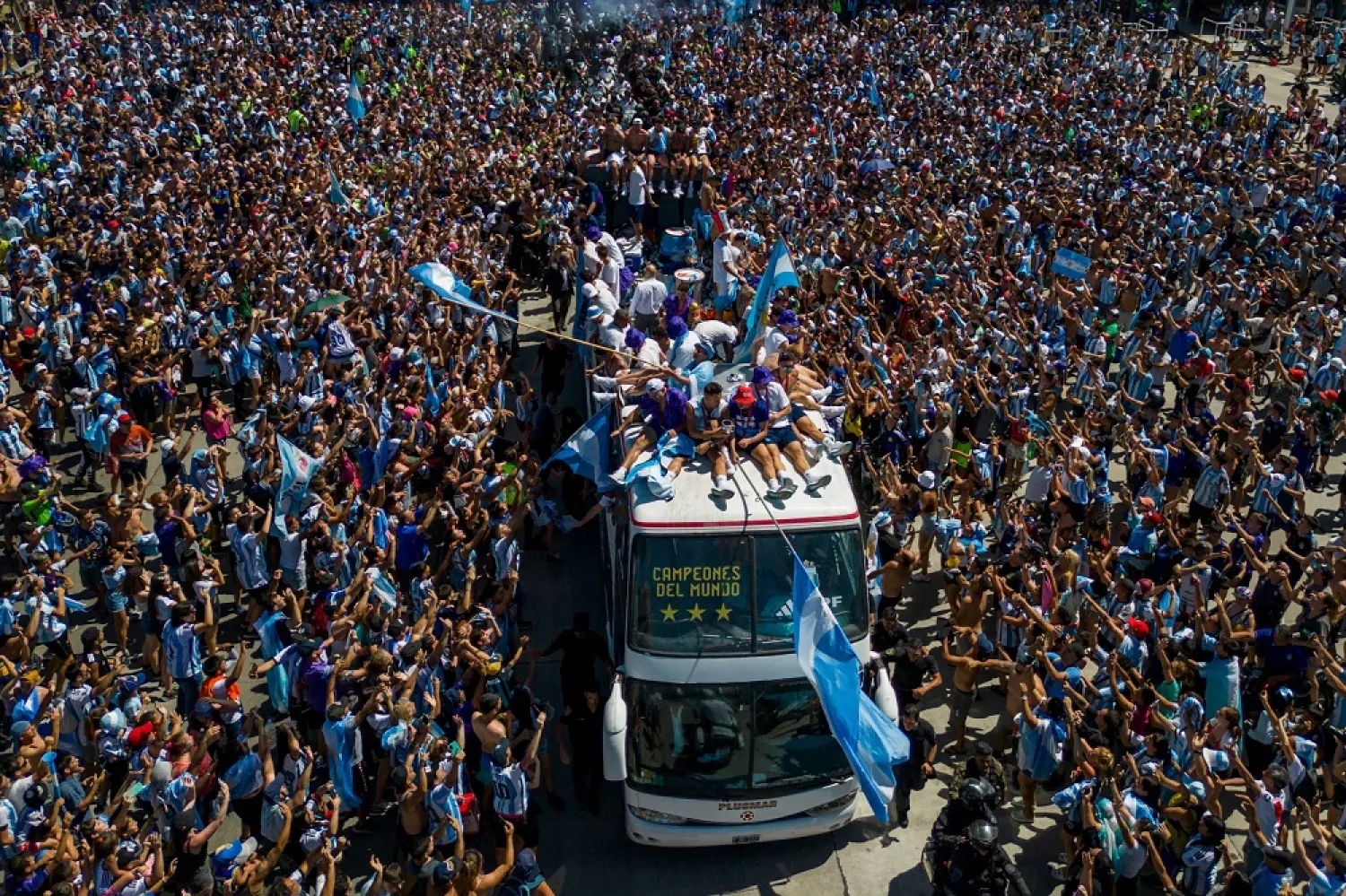 Argentina's players celebrate on board a bus with a sign reading "World Champions" with supporters after winning the Qatar 2022 World Cup tournament as they tour through Buenos Aires' downtown on December 20, 2022. (AFP)