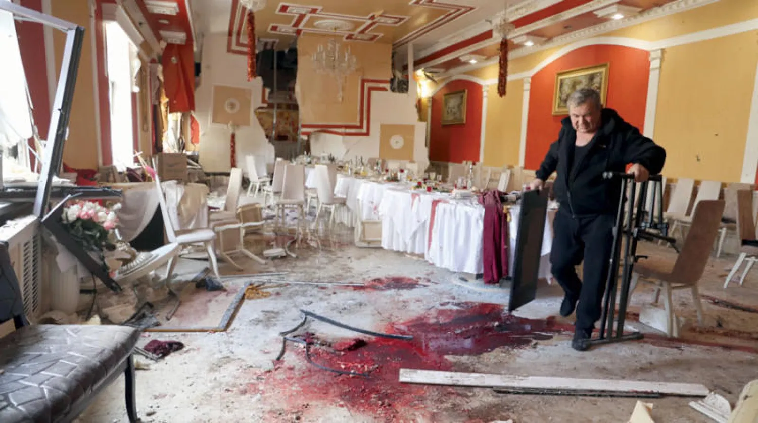 رجل يتفقد آثار الدماء والدمار التي خلفها قصف على مطعم في دونيتسك أمس (أ.ب)