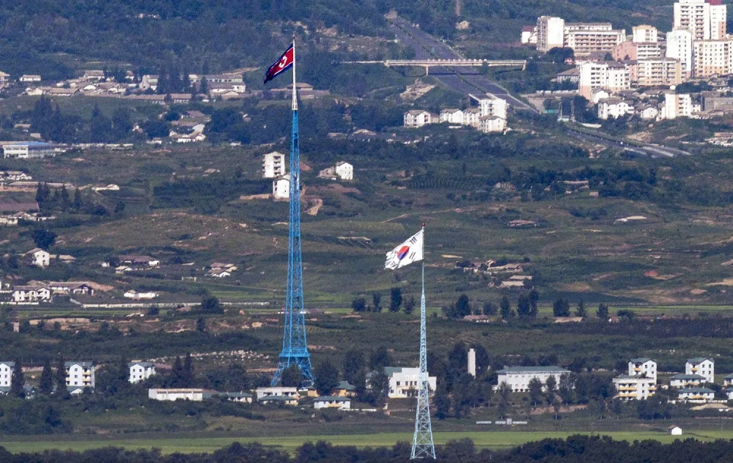 Flags of North Korea, rear, and South Korea, front, flutter in the wind as pictured from the border area between two Koreas in Paju, South Korea, on Aug. 9, 2021. (Yonhap via AP, File)
