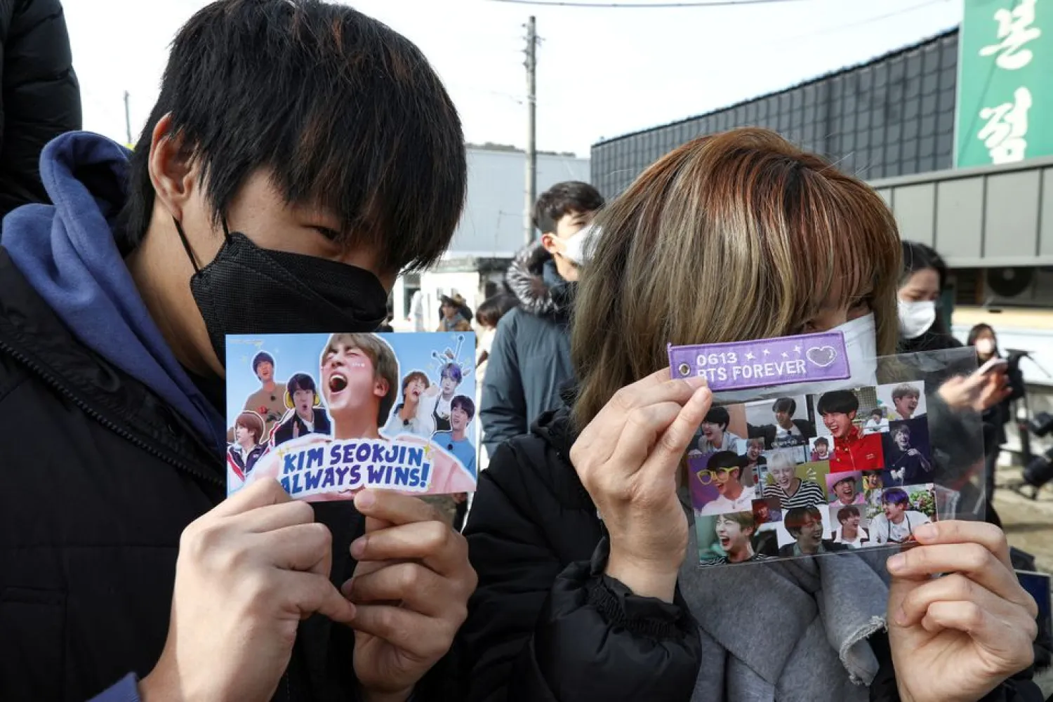 Fans hold up cards with pictures on it as they wait for the arrival of Jin, the oldest member of the K-pop band BTS, outside a South Korean army boot camp near the demilitarized zone separating the two Koreas, in Yeoncheon, South Korea December 13, 2022. REUTERS/Heo Ran/File Photo








