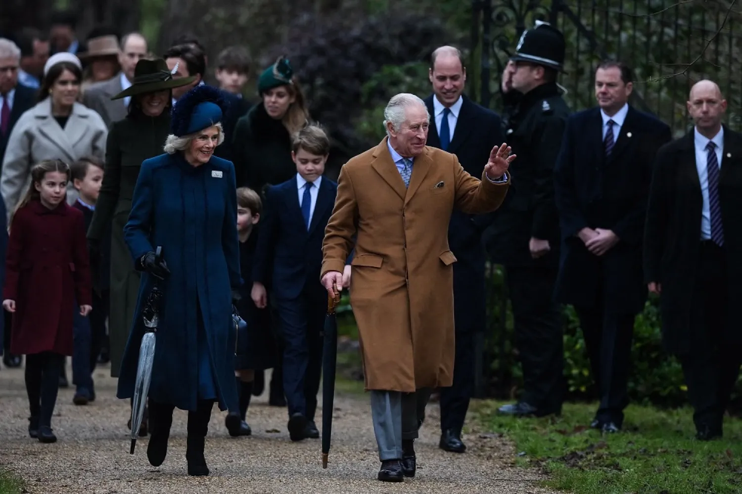 Britain's King Charles III (R) flanked by Britain's Camilla, Queen Consort (L) waves to members of the public as he arrives for the Royal Family's traditional Christmas Day service at St Mary Magdalene Church in Sandringham, Norfolk, eastern England, on December 25, 2022. (AFP)