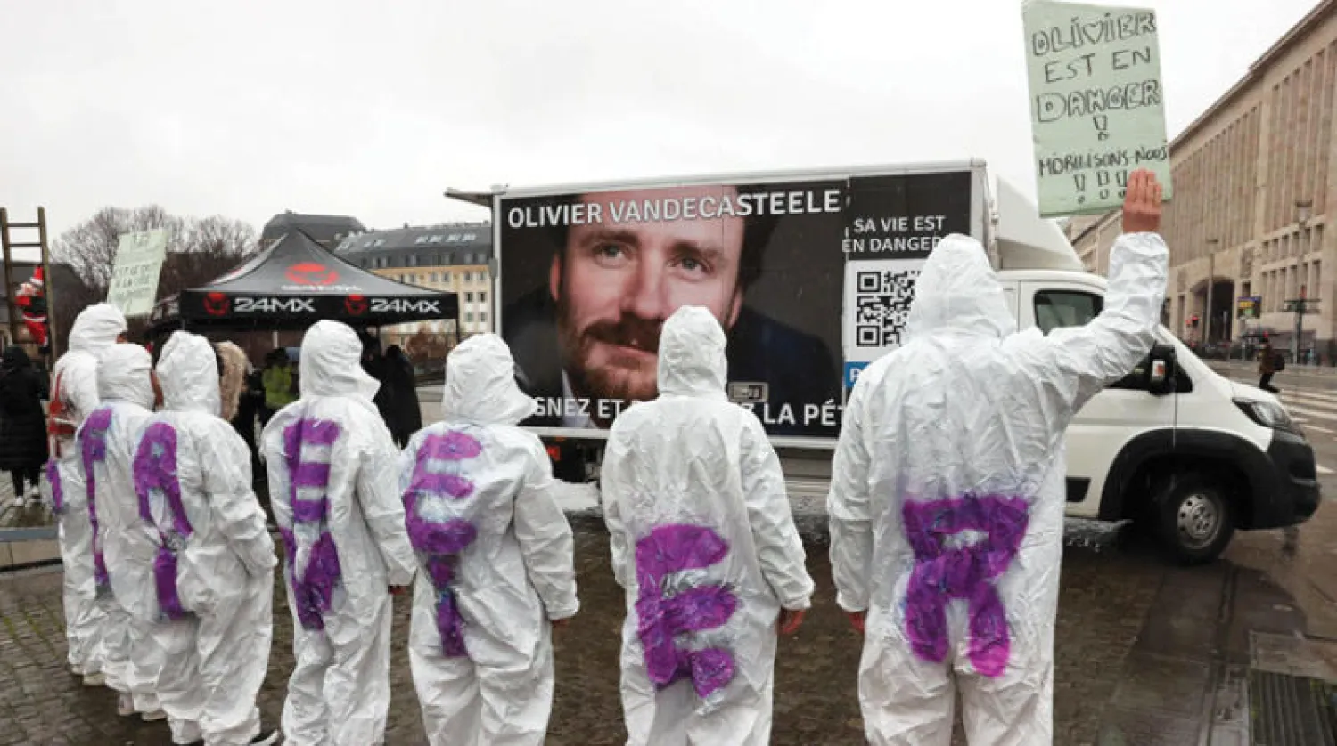 متظاهرون يرتدون ملابس كتب عليها شعارات تطالب بإطلاق سراح أوليفييه في بروكسل