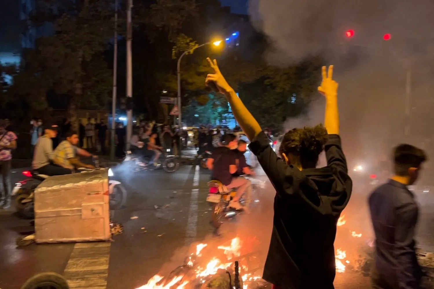 A demonstrator raises his arms during a protest for Mahsa Amini, Tehran, Iran, Sept. 19, 2022. (AFP)
