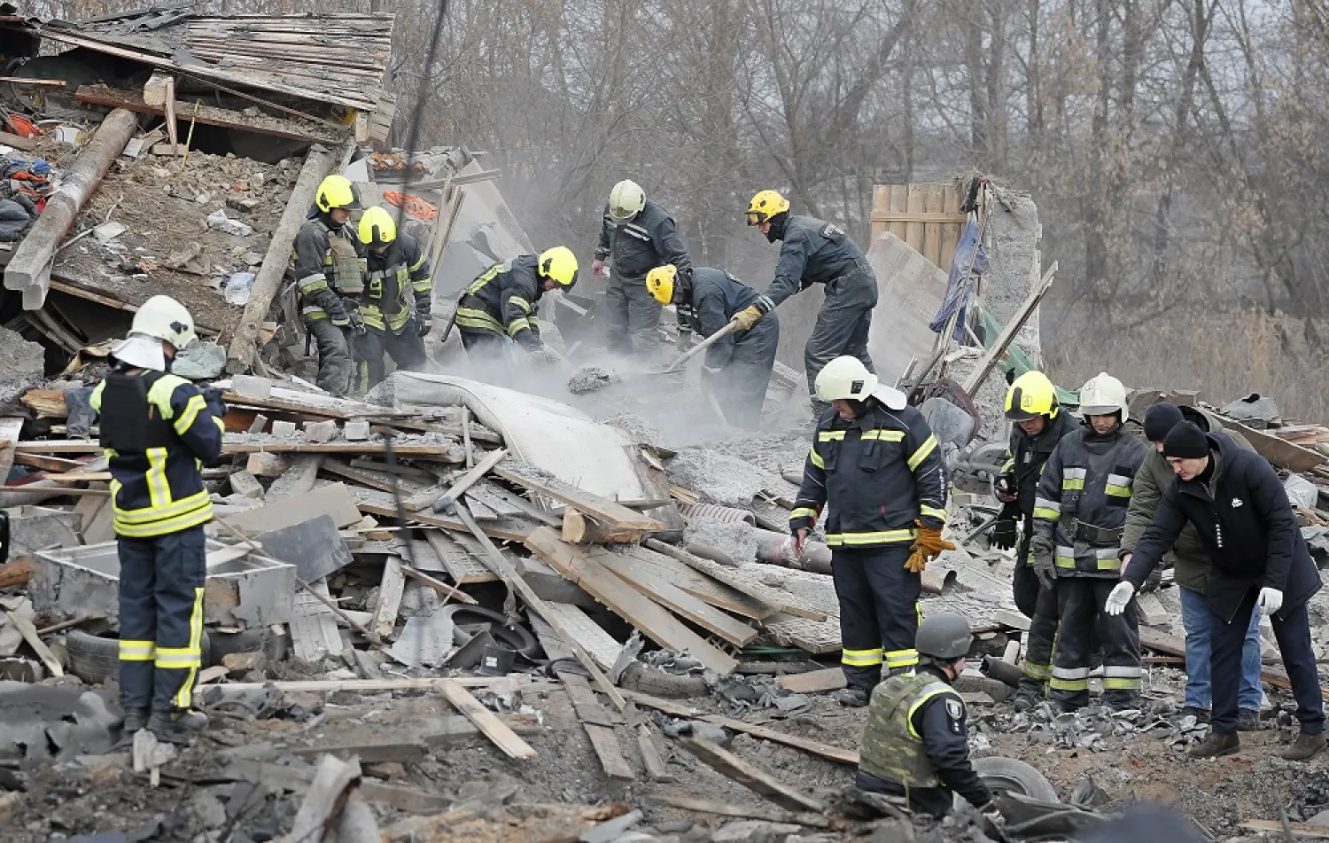 Ukrainian rescue workers at the scene of a destroyed residential building following a Russian missile strike in the outskirts of Kyiv, Ukraine, 29 December 2022. (EPA)
