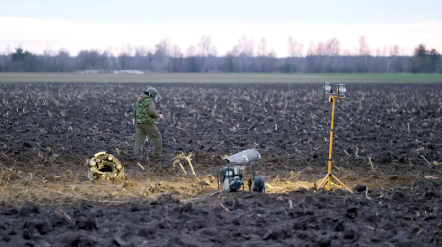 محقق عسكري يتفقد شظايا صاروخ في بيلاروس في 29 ديسمبر (إ.ب.أ)