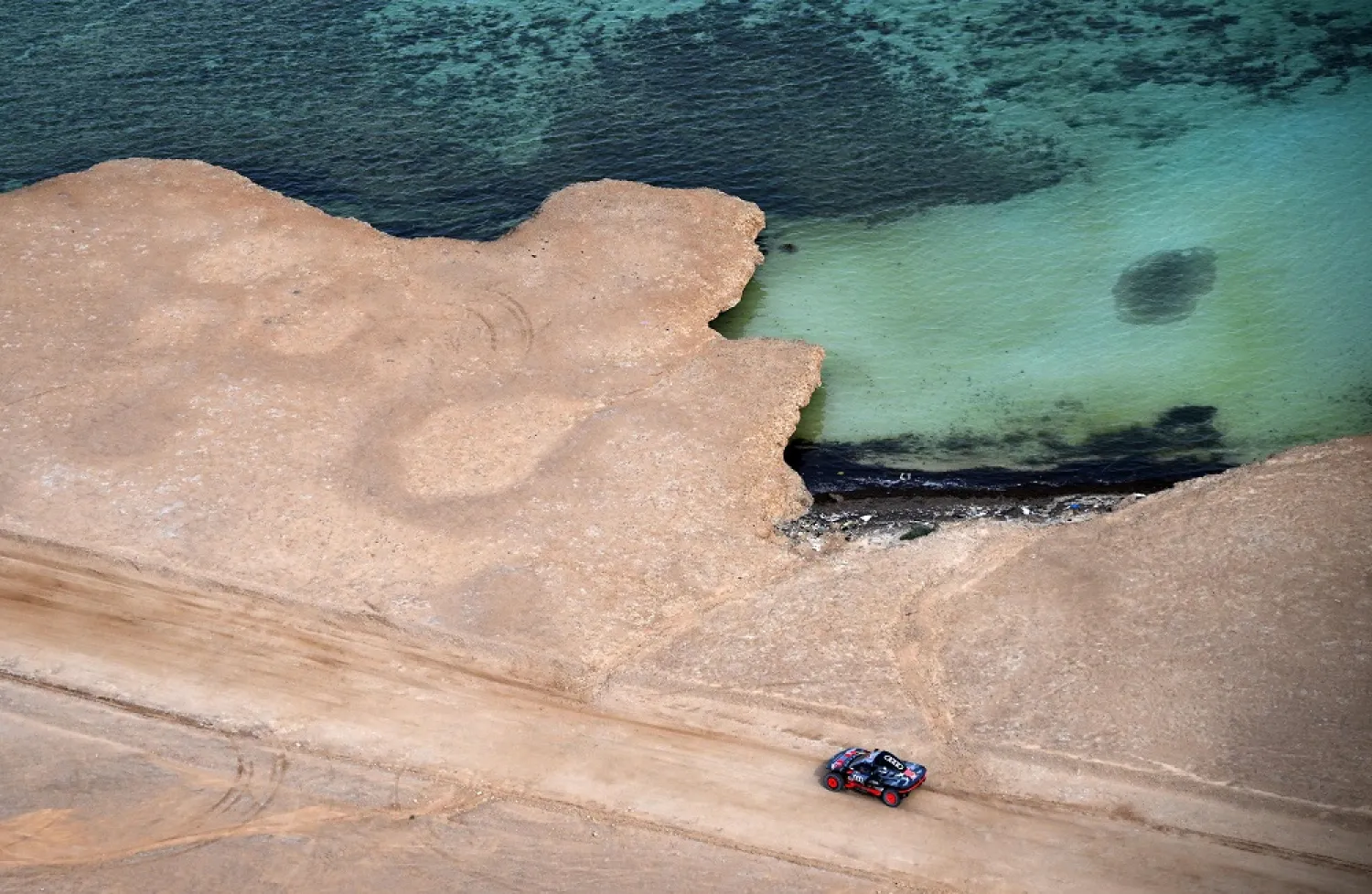 Audi's hybrid Spanish driver Carlos Sainz and co-driver Lucas Cruz compete during the prologue of the Dakar 2023 by the Red Sea in Yanbu, Saudi Arabia, on December 31, 2022. (AFP)