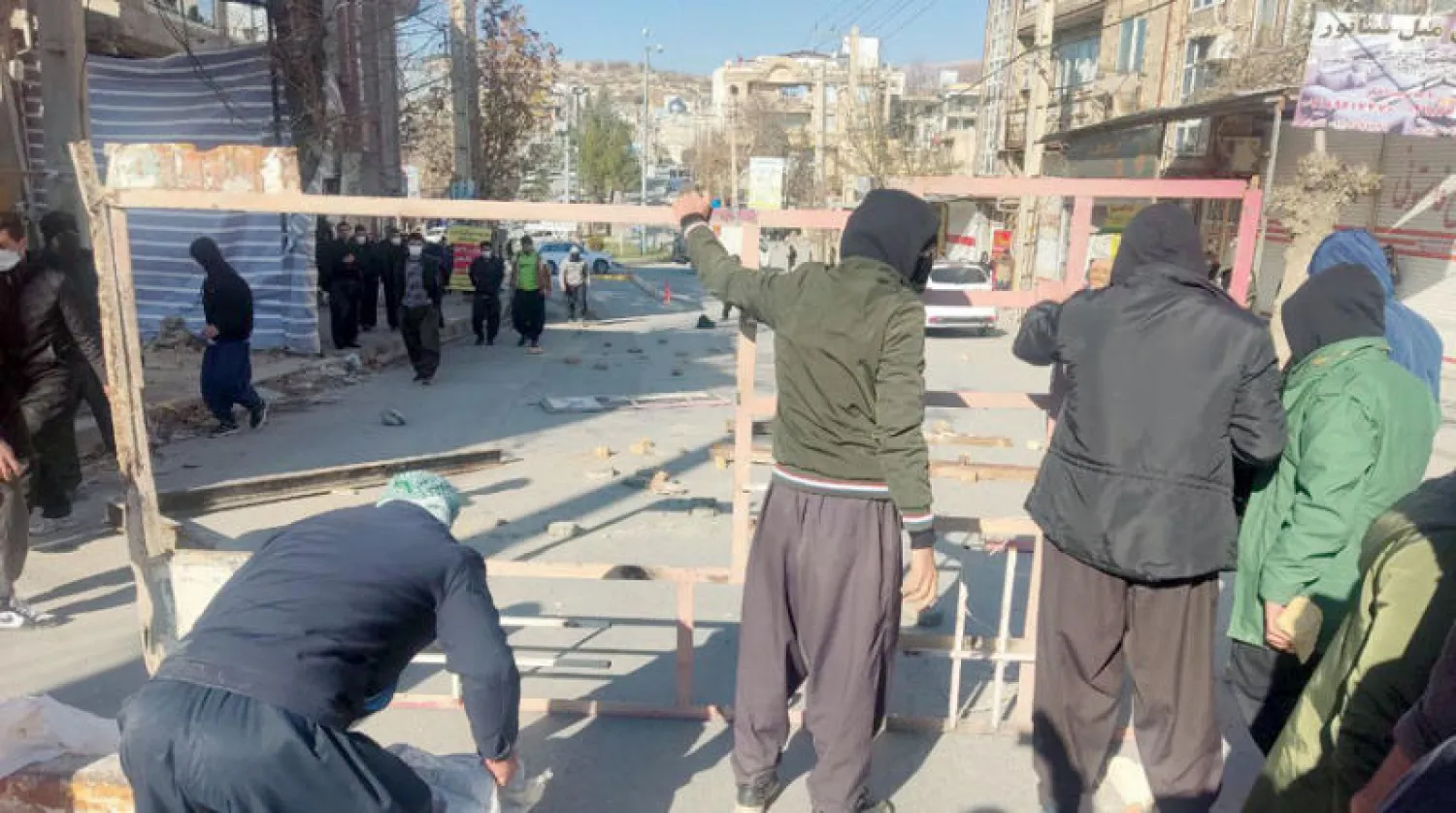 محتجون يحاولون إقامة حواجز في شارع بمدينة جوانرود (تويتر)
