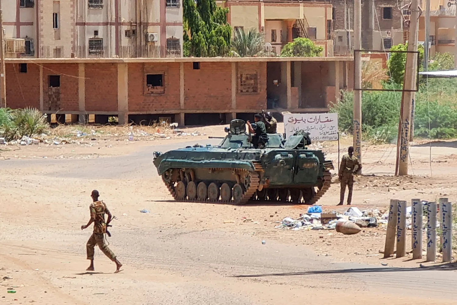 Sudanese Army soldiers walk near tanks stationed on a street in southern Khartoum, on May 6, 2023, amid ongoing fighting against the Rapid Support Forces. (Photo by AFP)