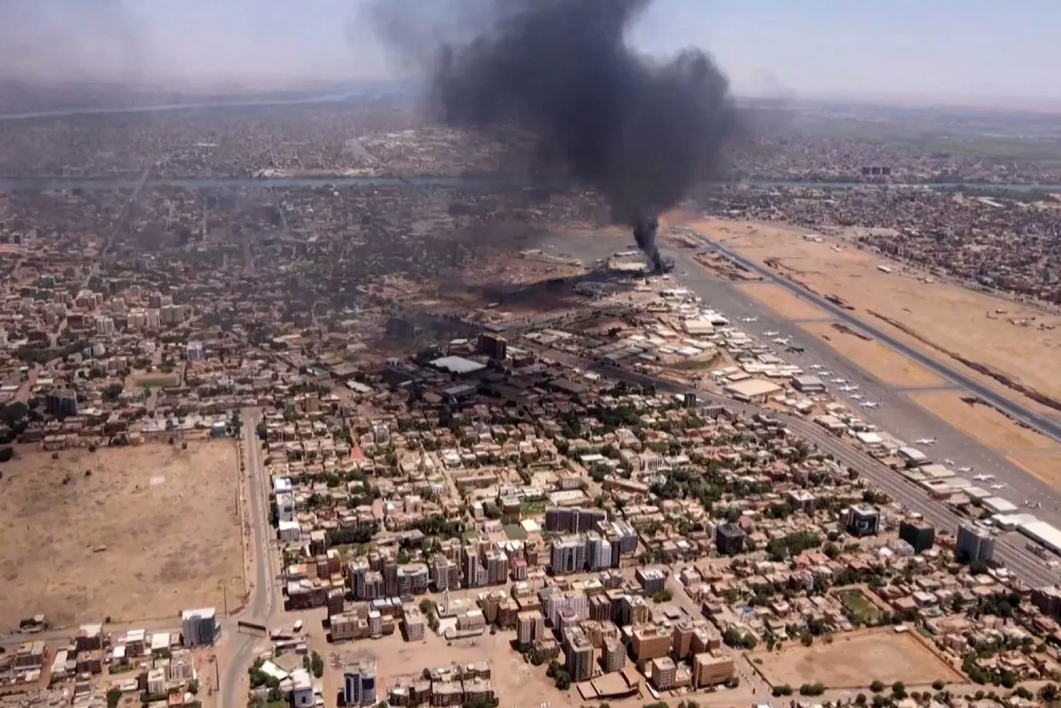 This video grab taken from AFPTV video footage on April 20, 2023, shows an aerial view of black smoke rising above the Khartoum International Airport amid ongoing battles between the forces of two rival generals. (AFP)
