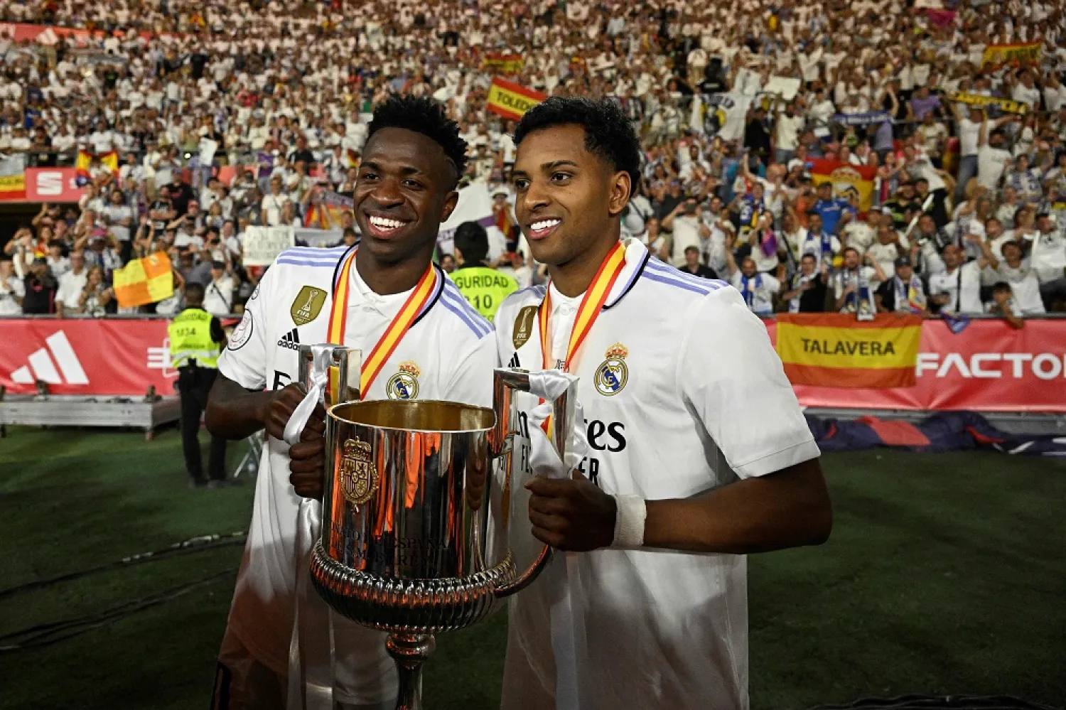 Real Madrid's Brazilian forward Vinícius Júnior and Real Madrid's Brazilian forward Rodrygo (R) celebrate with the King's Cup trophy at the end of the Spanish Copa del Rey (King's Cup) final football match between Real Madrid CF and CA Osasuna at La Cartuja stadium in Seville on May 6, 2023. (AFP) 