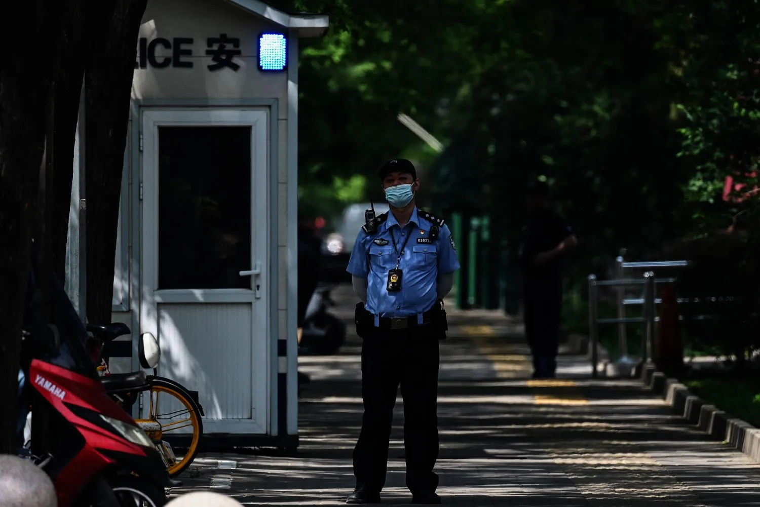 A police officer stands outside the Canadian embassy in Beijing on May 9, 2023. (Photo by GREG BAKER / AFP)