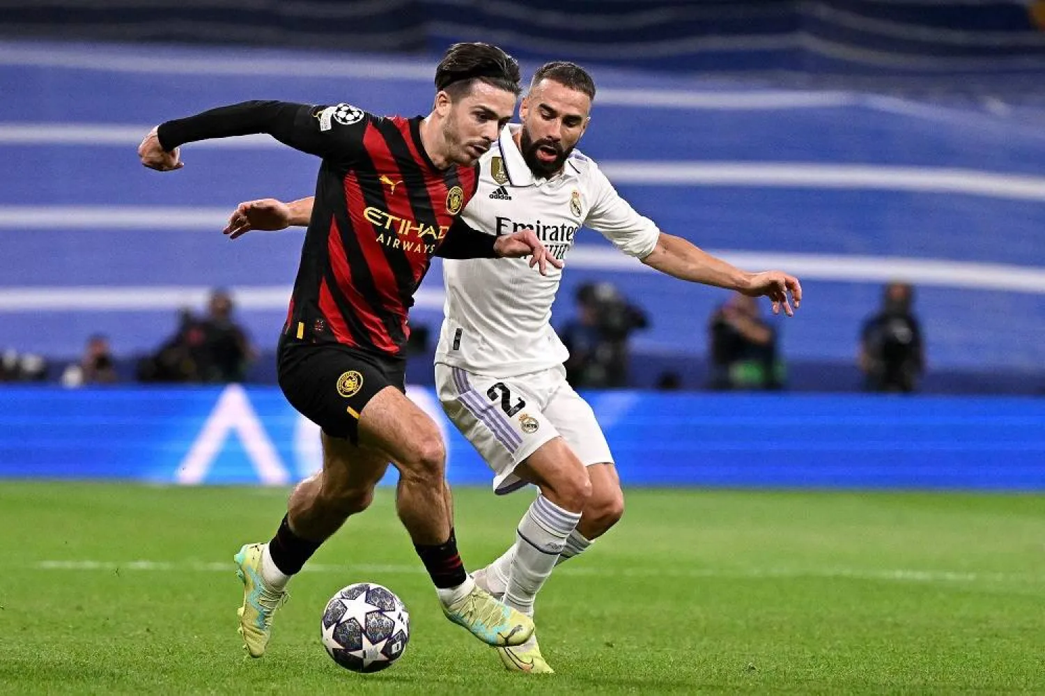 Manchester City's English midfielder Jack Grealish (L) vies with Real Madrid's Spanish defender Dani Carvajal during the UEFA Champions League semi-final first leg football match between Real Madrid CF and Manchester City at the Santiago Bernabeu stadium in Madrid on May 9, 2023. (AFP) 