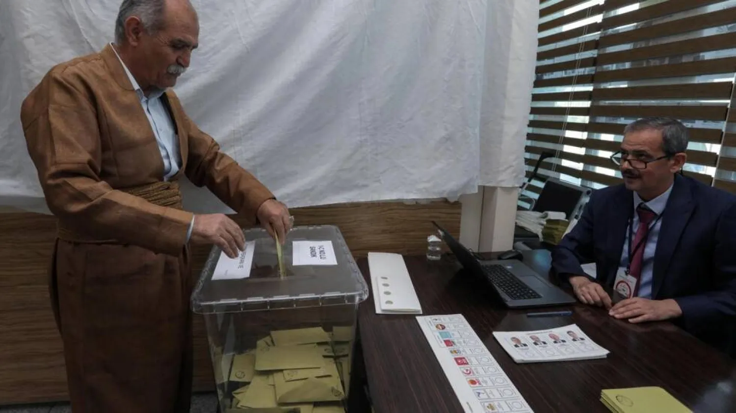 A Turkish citizen living in Arbil, the capital of the autonomous Kurdish region of northern Iraq, casts his ballot for the presidential and parliamentary elections, at the Turkish embassy. SAFIN HAMED / AFP

