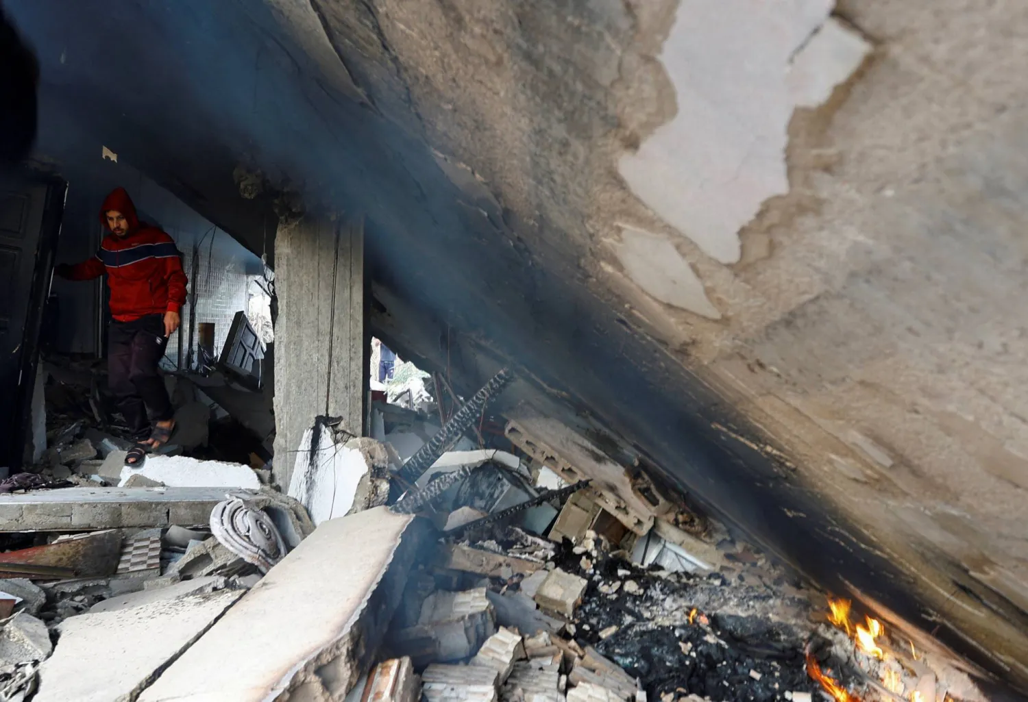 A man walks through the site of an Israeli airstrike amid Israel-Gaza fighting in Deir al-Balah town in the central Gaza Strip, May 12, 2023. REUTERS/Ibraheem Abu Mustafa    